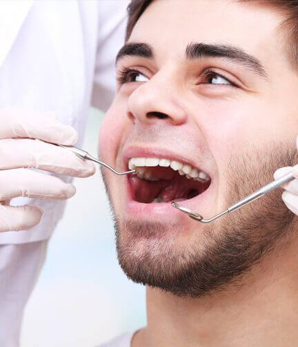 Young man smiling with mouth open, preparing for dental cleaning